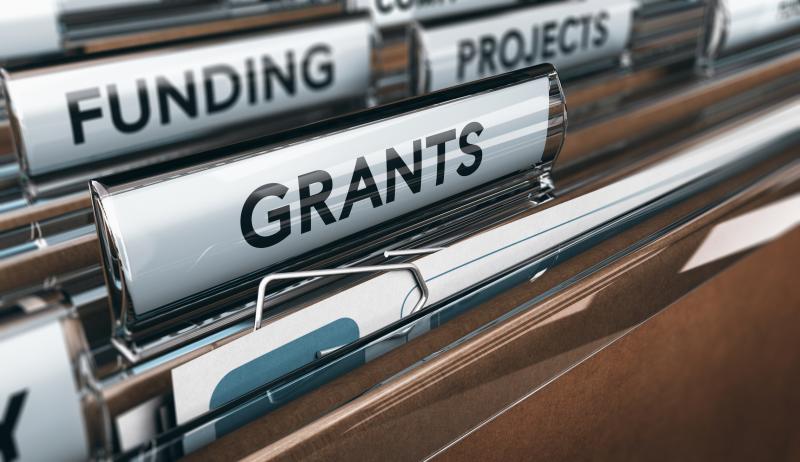 Concept photograph of funding.  View of brown folders, with focus on grants label.