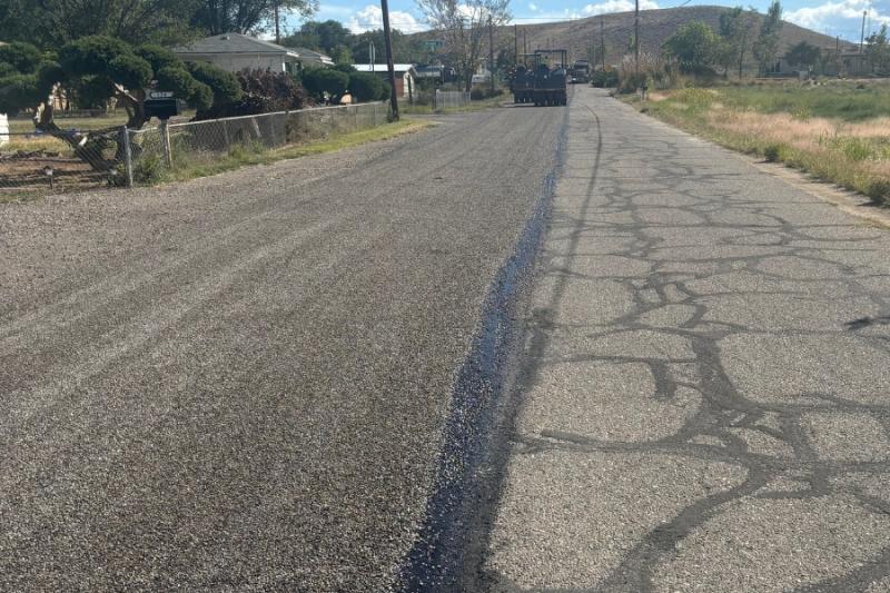 Newly paved road next to old black road. 