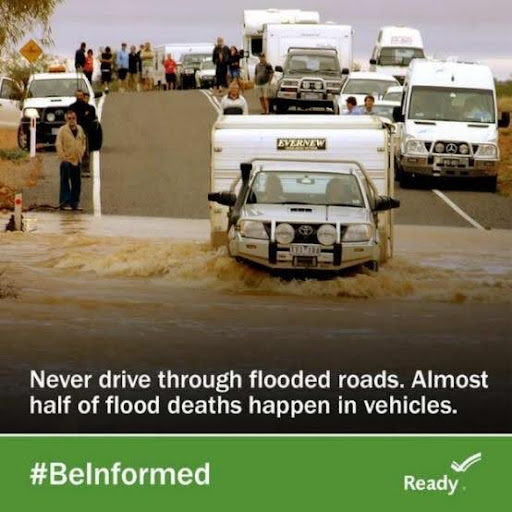 A car driving through a flooded road with text that reads Never drive through flooded roads. Almost half of flood deaths happen in vehicles.