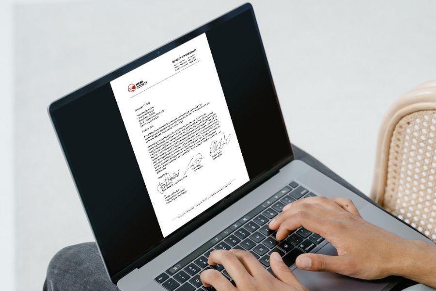 Person on a laptop pulling up a letter 