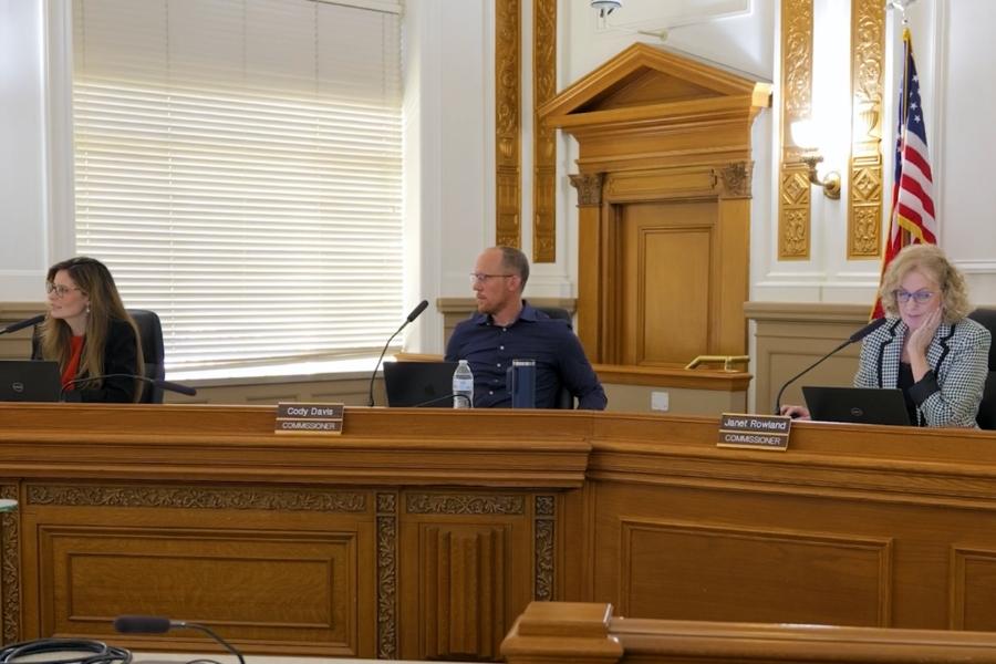Mesa County Commissioners sit in public hearing room. 