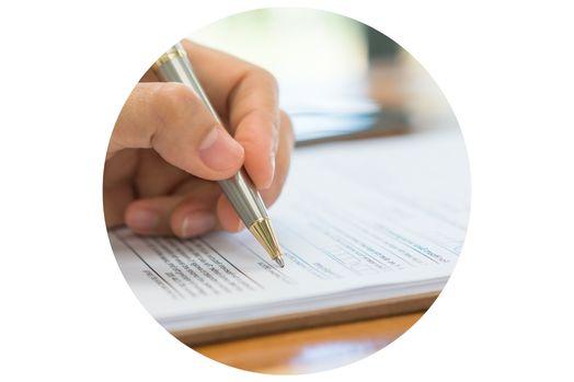Close up image of hand holding a pen and filling out an application.