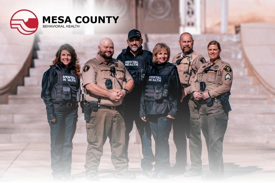 Group of law enforcement and mental health professionals smiling. 