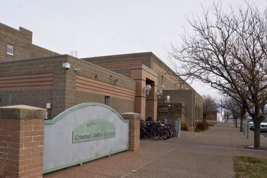 Brick building next to  trees with a green sign reading, "Mesa County Criminal Justice Services."