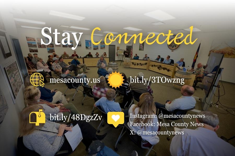 Crowd sitting at a town hall with white and yellow text reading, Stay Connected, mesacounty.us, bit.ly/3TOwzng , bit.ly/48DgzZv , Instagram: @mesacountynews Facebook: Mesa County News X: @mesacountynews. 