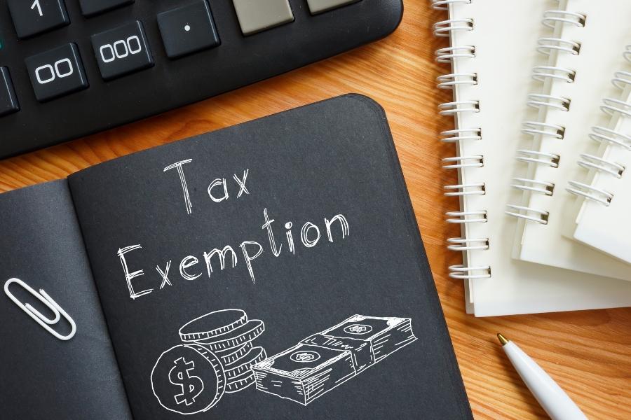 A book with white text reading Tax Exemption and a white drawing of money.