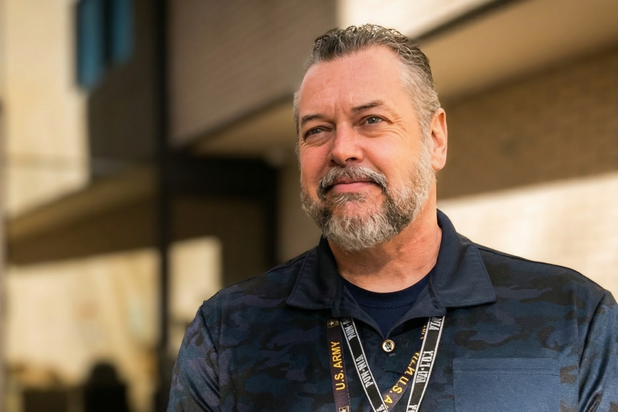 Anthony “Tony” Lee, Mesa County Veterans Service Officer, standing outside the old Mesa County Courthouse wearing a U.S. Army lanyard.