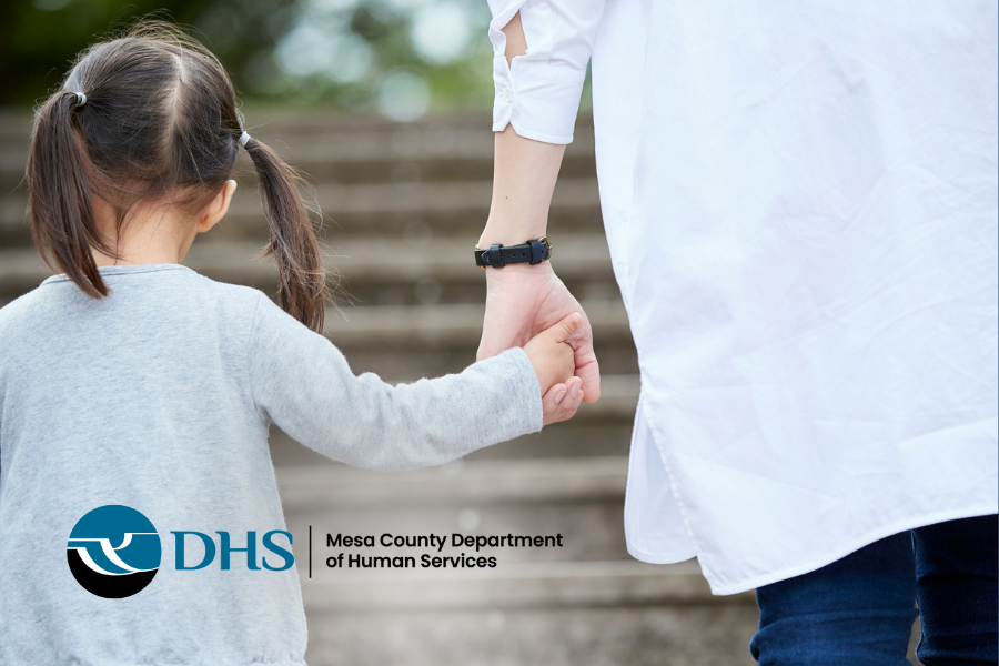 Child holding guardians hand with DHS logo