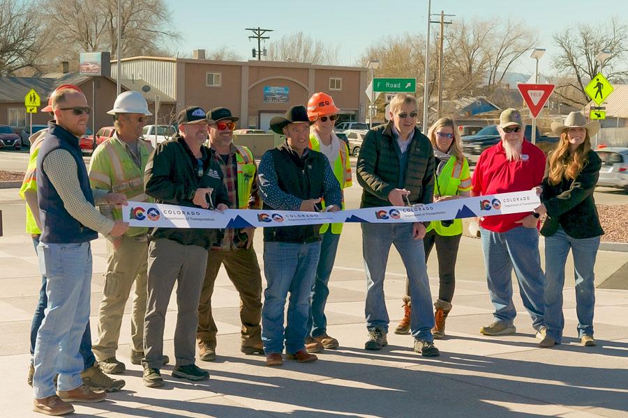 County officials, transportation partners and construction workers stand together at a ribbon cutting for the U.S. 6 Clifton Improvements Project, holding a Colorado Department of Transportation ribbon across a newly improved intersection with crosswalks and signage visible in the background.