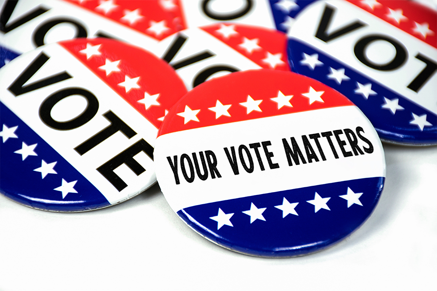 Red, white and blue “I Voted” buttons are stacked together, with one in the foreground reading “Your Vote Matters.”