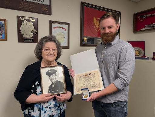 Isaac Labig with grandmother Mary Williams, holding awards for WWII veteran Merl Williams.