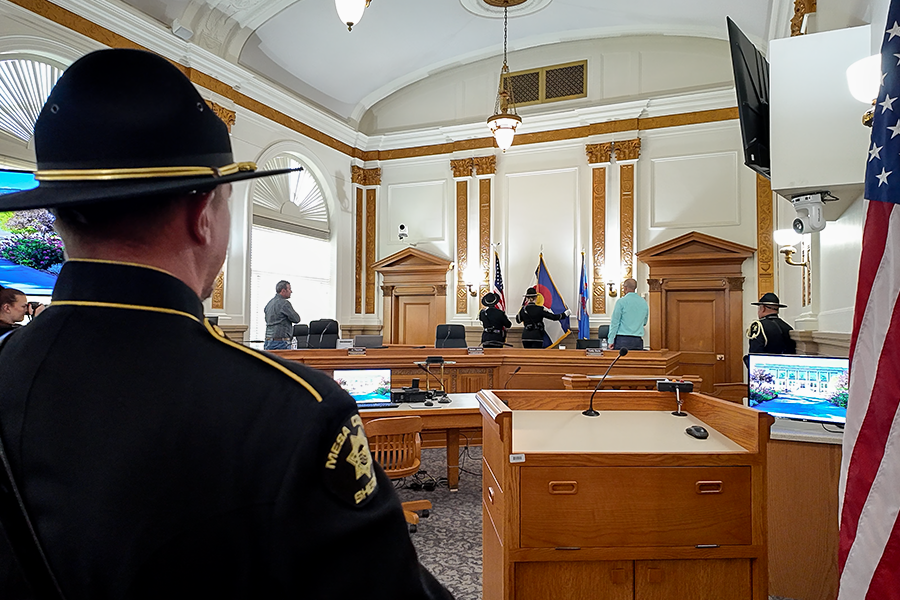 A Mesa County detention deputy stands in the foreground as the Honor Guard presents the colors during a Mesa County Commissioners public hearing recognizing Correctional Officers Week.