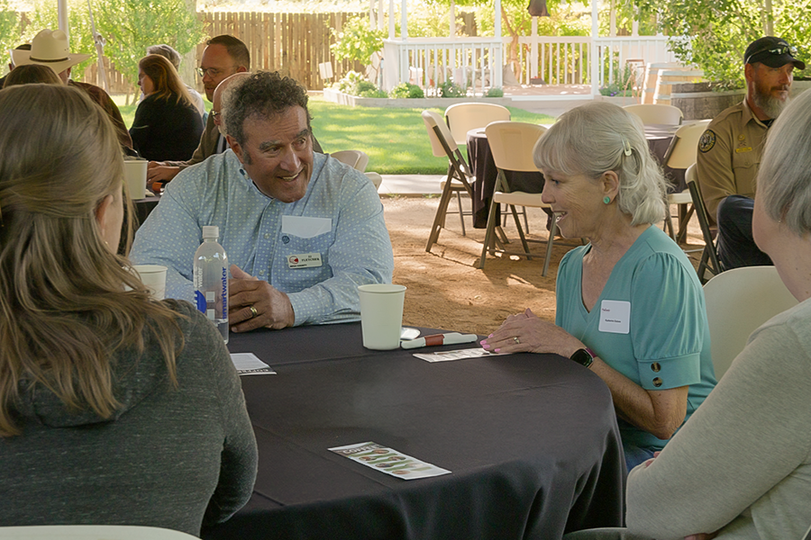 Mesa County Commissioner JJ Fletcher sits at a roundtable discussion with community members during the Palisade Chamber of Commerce's "Your Community Over Coffee" event.